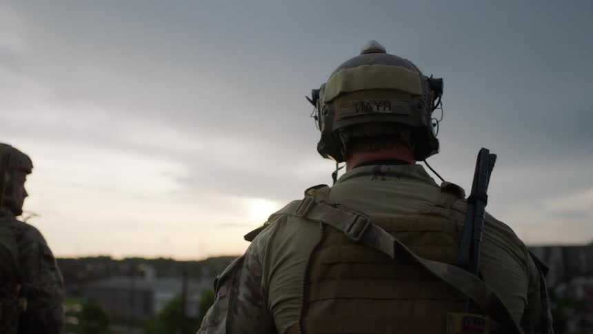 Soldiers stand guard overlooking a city
