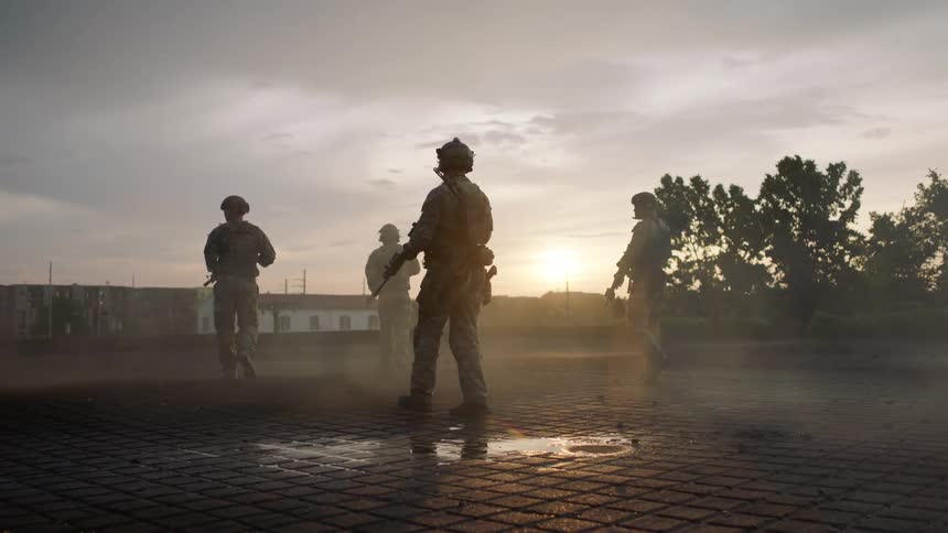 Soldiers are walking carrying their weapons at sunset