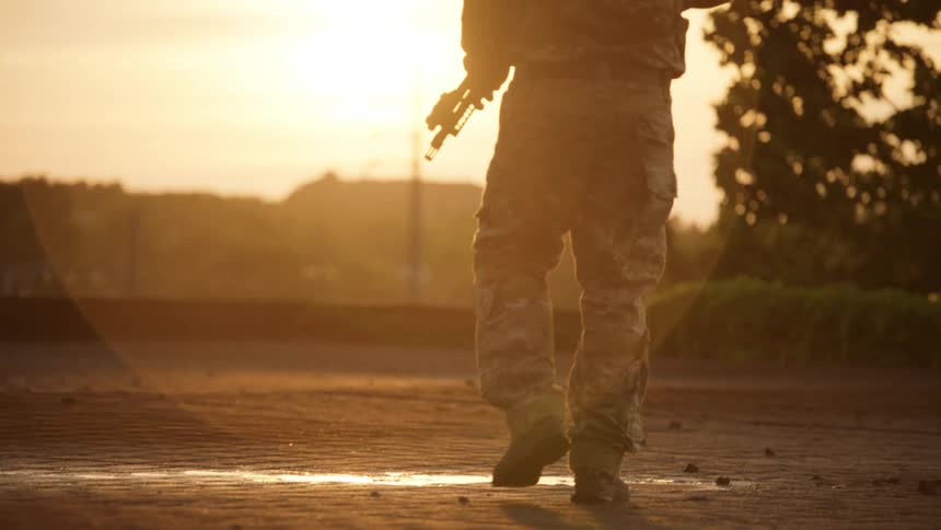 Uniformed men walk outside at sunset