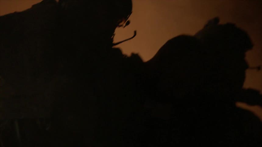 A soldier is helped up by two others at night