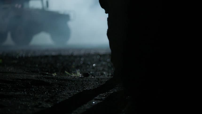 Soldiers walk outside at night