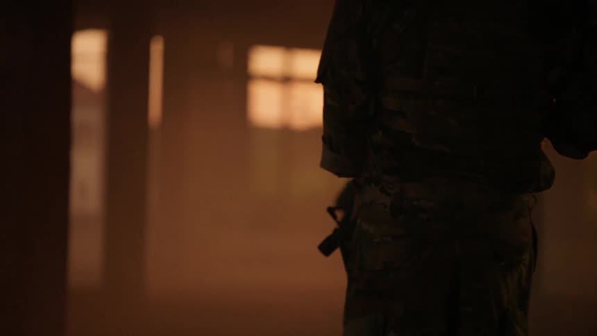 Soldiers walk through the bottom of a building