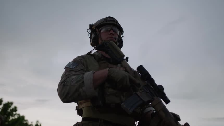 A soldier stands guard holding his rifle