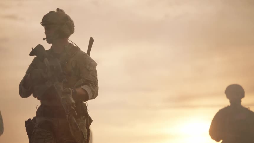 Soldiers patrol while carrying their rifles