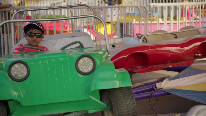 A young boy rides a carnival attraction