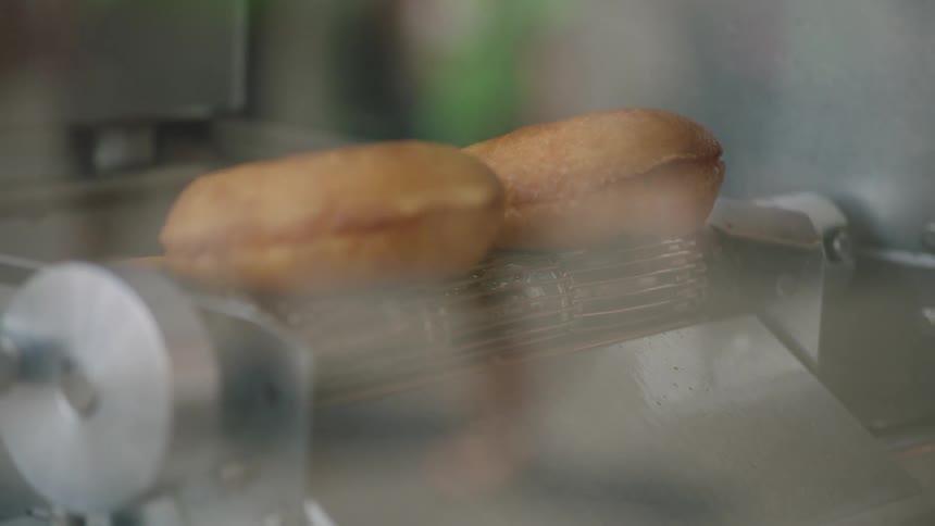 Bagels falling off of a conveyor belt