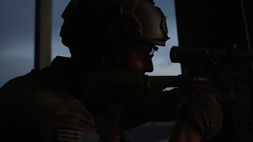 A sniper aims his gun looking through the sights
