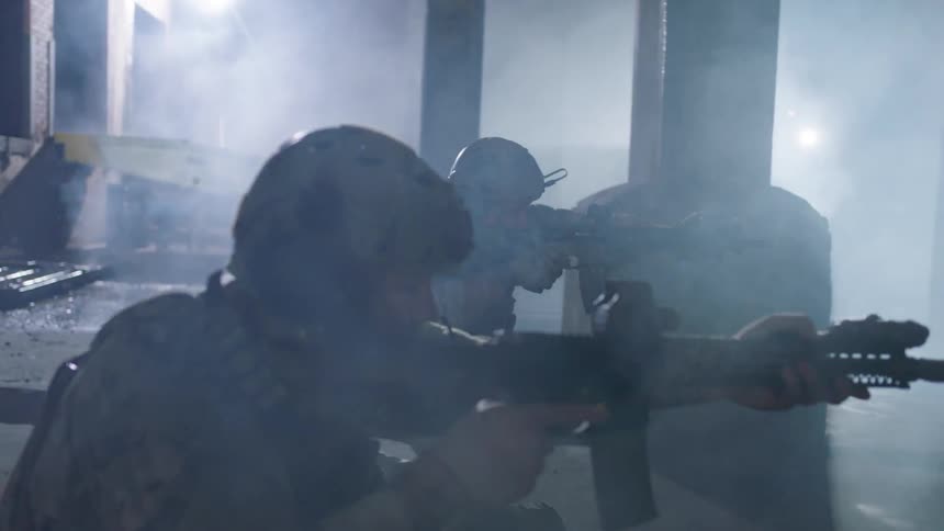 Army men are in abandoned building aiming automatic rifles