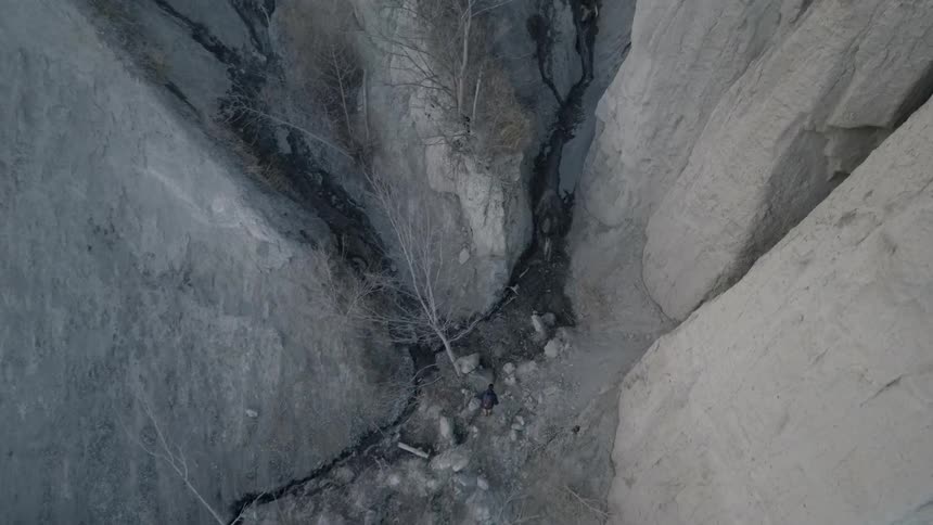 A person runs through a large crevice between rocks