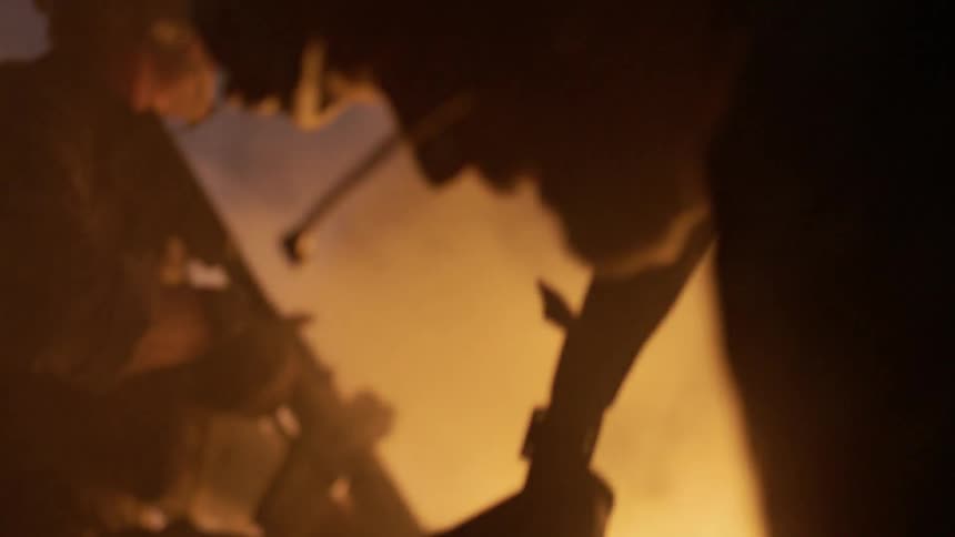 The soldiers search around in the fire and smoke filled area