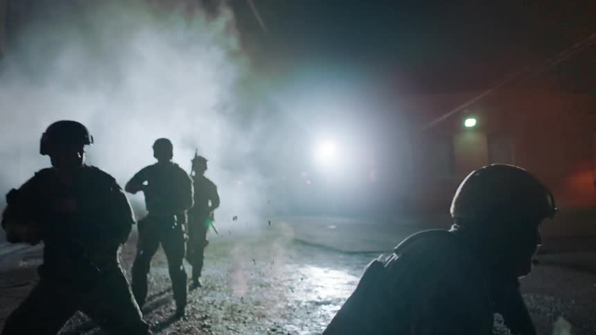 Soldiers take and return fire in the street at night