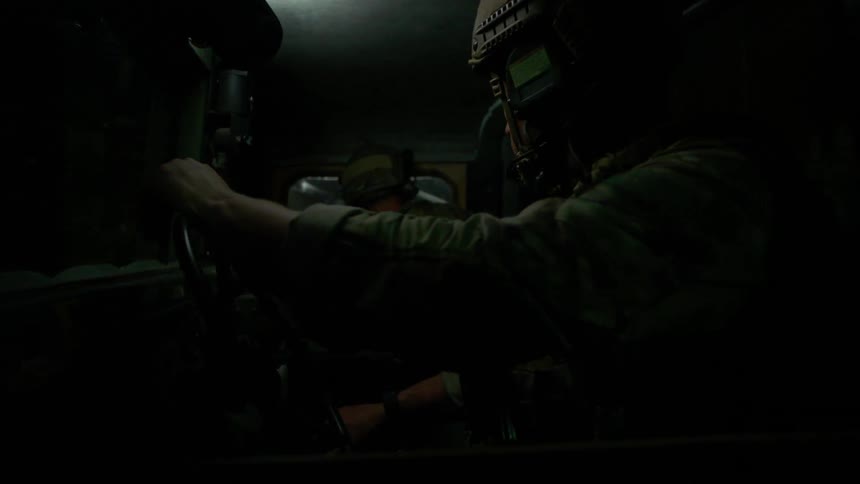 A soldier drives a vehicle at night
