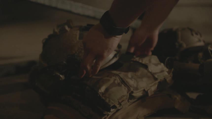 Soldier places their folded up uniform on the ground
