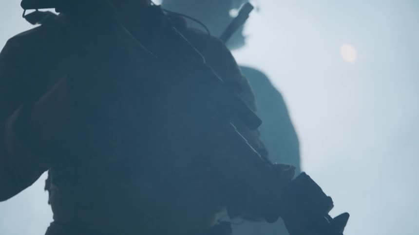Soldiers stand guard in the haze while holding their rifles