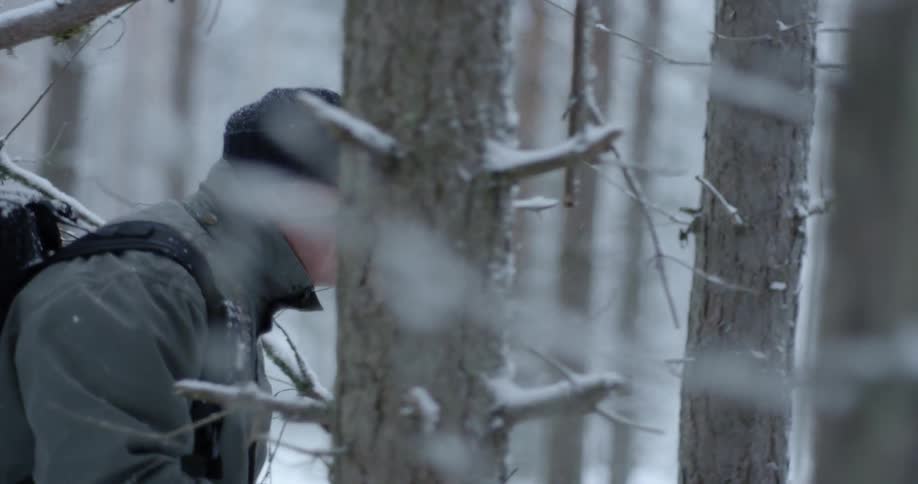 A man hikes through a snowy forest