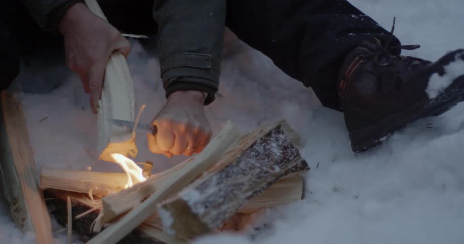 A man is carving wood with a small knife