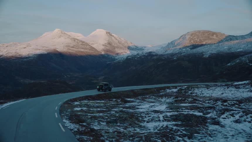 A truck travels down a snowy mountain road