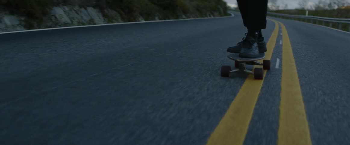 A man rides a skateboard down the street