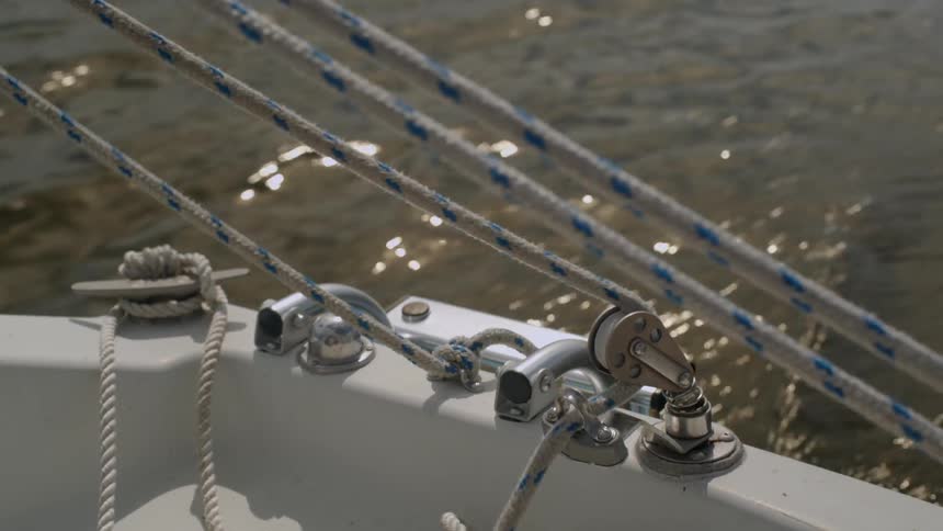 Person pulls rope on a boat to adjust sails