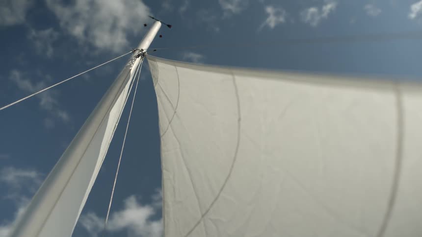 An skyward view of a sailboat's sail and mast