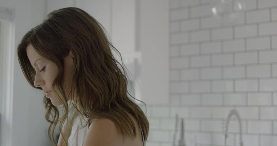 A woman stands in the kitchen and looks around