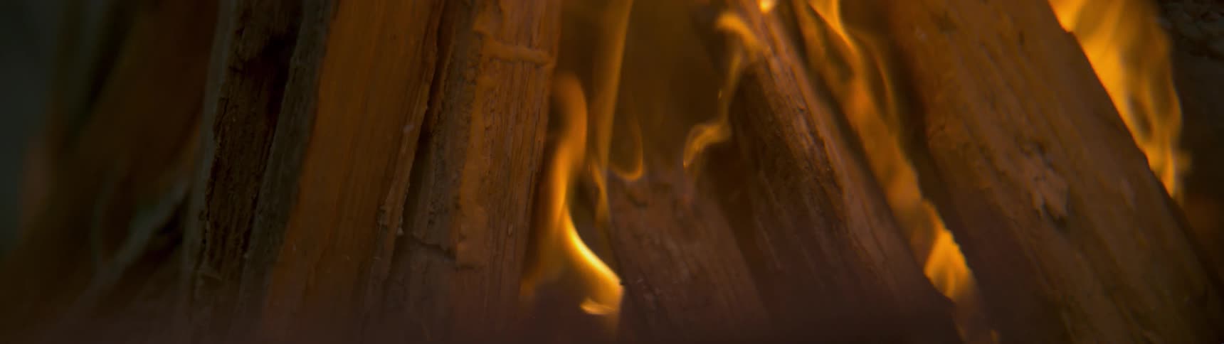 A wood fire burns with glowing orange flames