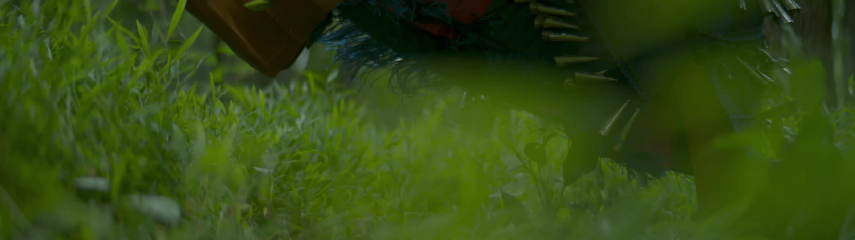 A native dances outside in a field with full costume on