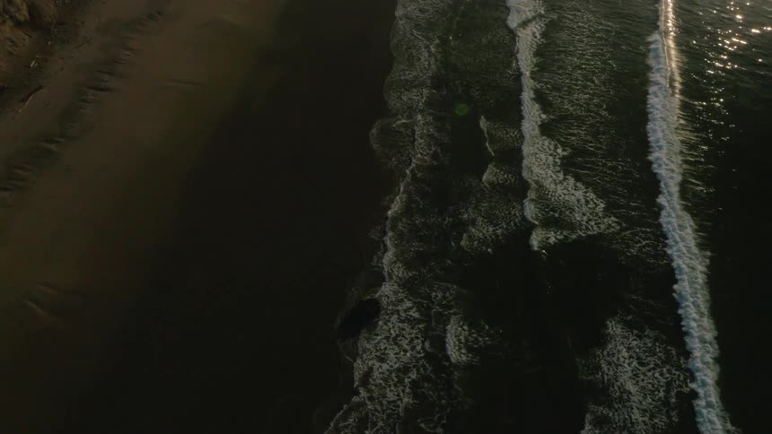 Ocean waves wash ashore a sandy beach
