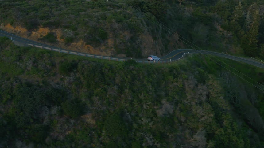 Cars travel down a curving mountain road