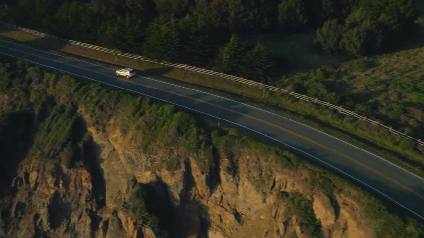 A car drives down the road on a sunny day