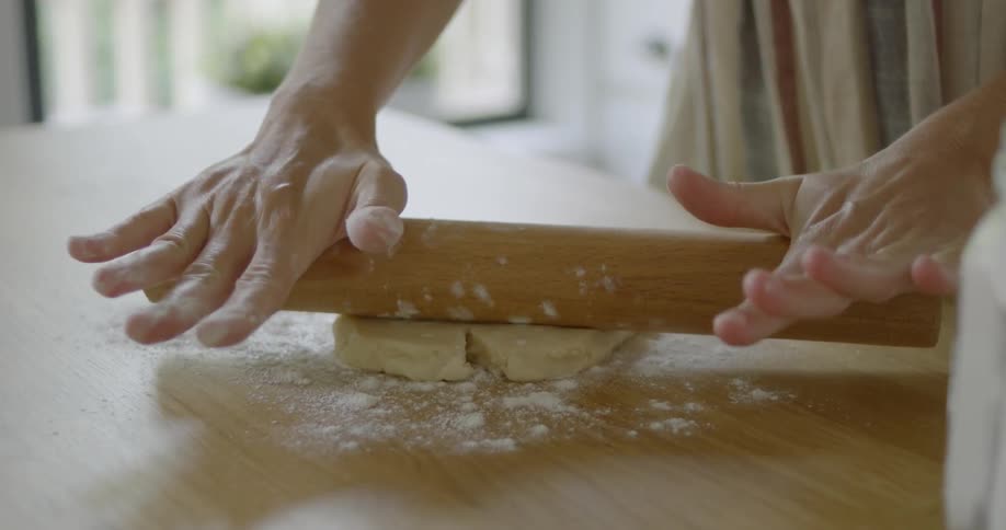 A person rolls dough