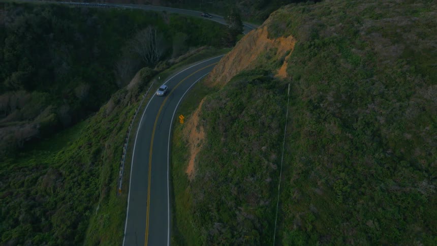 Cars traveling on windy coastal mountain highway