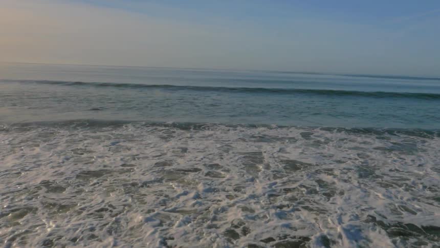 Waves flow onto the beach shore