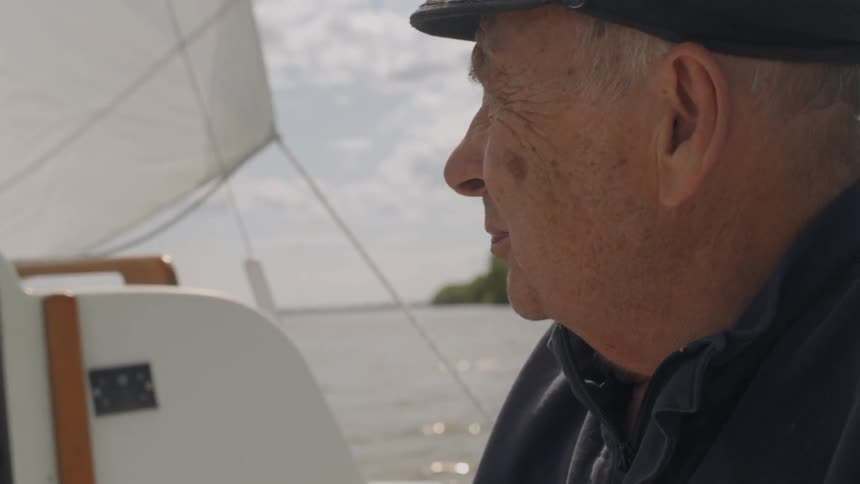 A man steers a sailboat