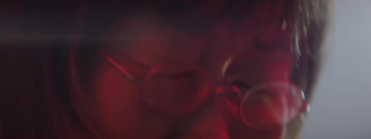 An elderly woman closes her eyes and shakes her head violently