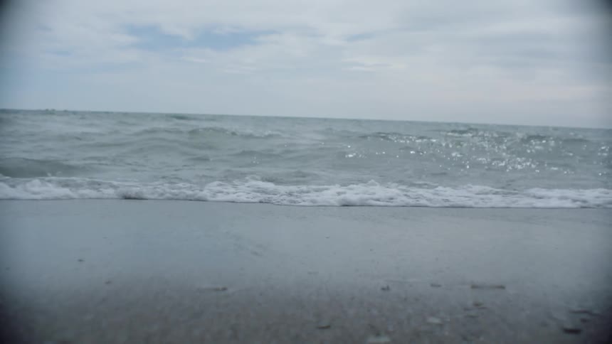 The waves slowly crash on the sand