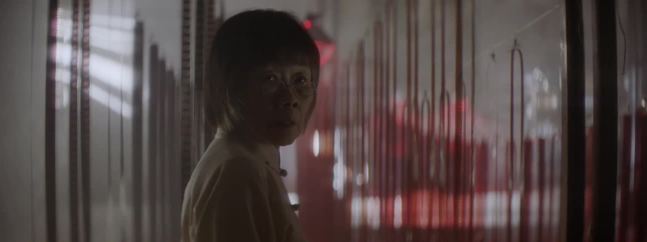 A woman turns around in a dark room used for developing film