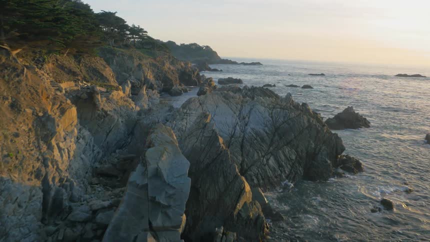 Waves splash against the rocky shore line