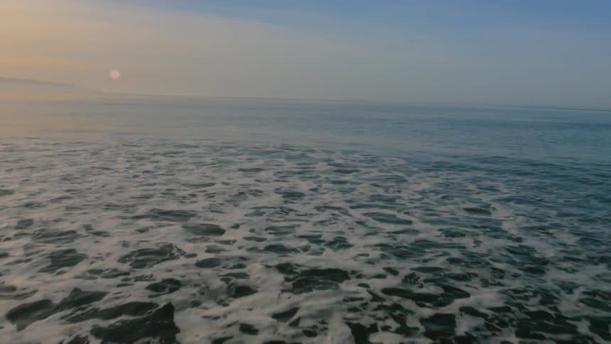 The tide flows onto the beach shore