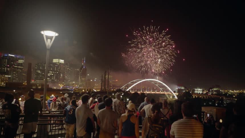 Crowd Watches Fireworks Over City Skyline