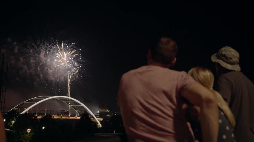 Family Watching Fireworks Over A Bridge