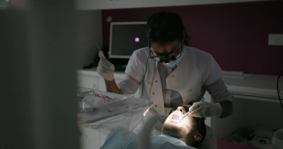 A dentist works on a patient in her office