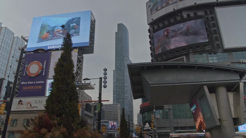 Time lapse of a city on a cloudy day with the advertisements moving fast