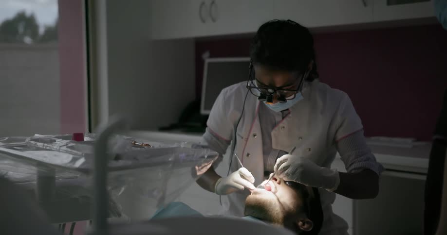A dentist examines a patient's teeth