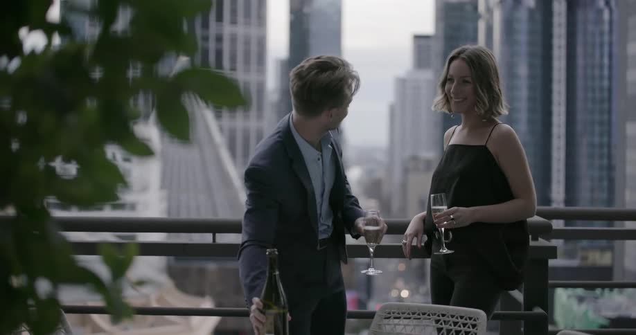 Man and woman are standing and talking on balcony in city