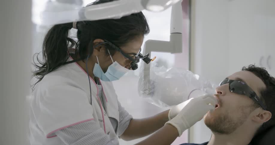 A dentist works on a patient