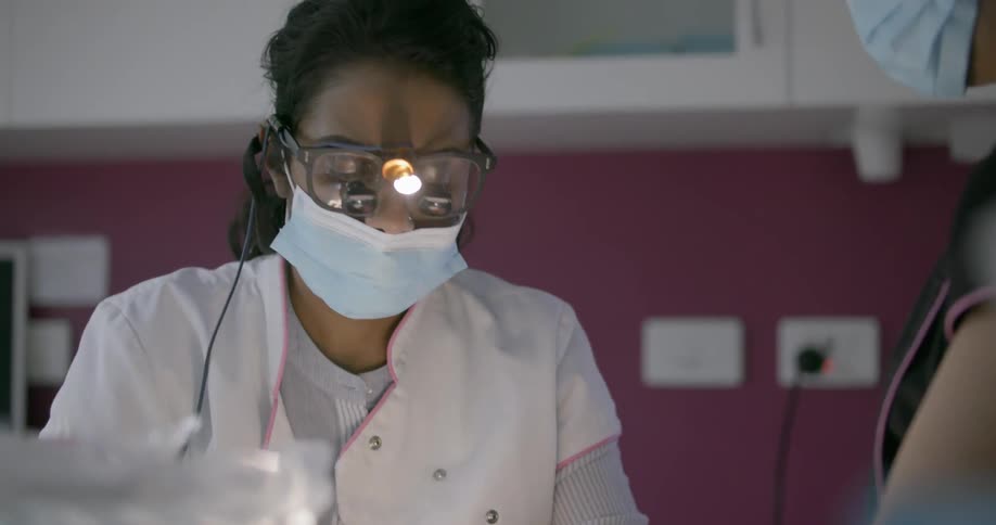 A dentist is working on a person's teeth