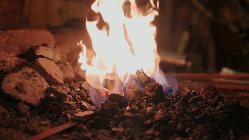 A flame burns on a pile of rocks