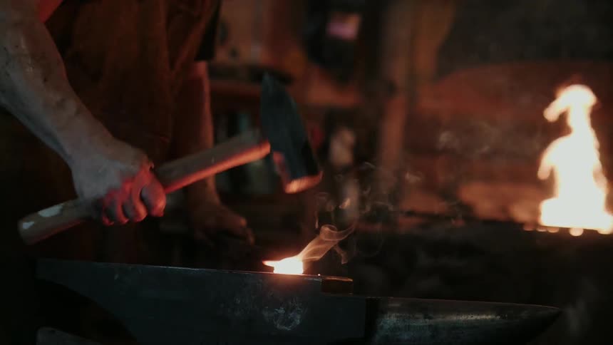 Sparks fly as a blacksmith hammers hot metal