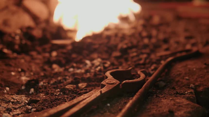 A fire burns inside a blacksmith kiln